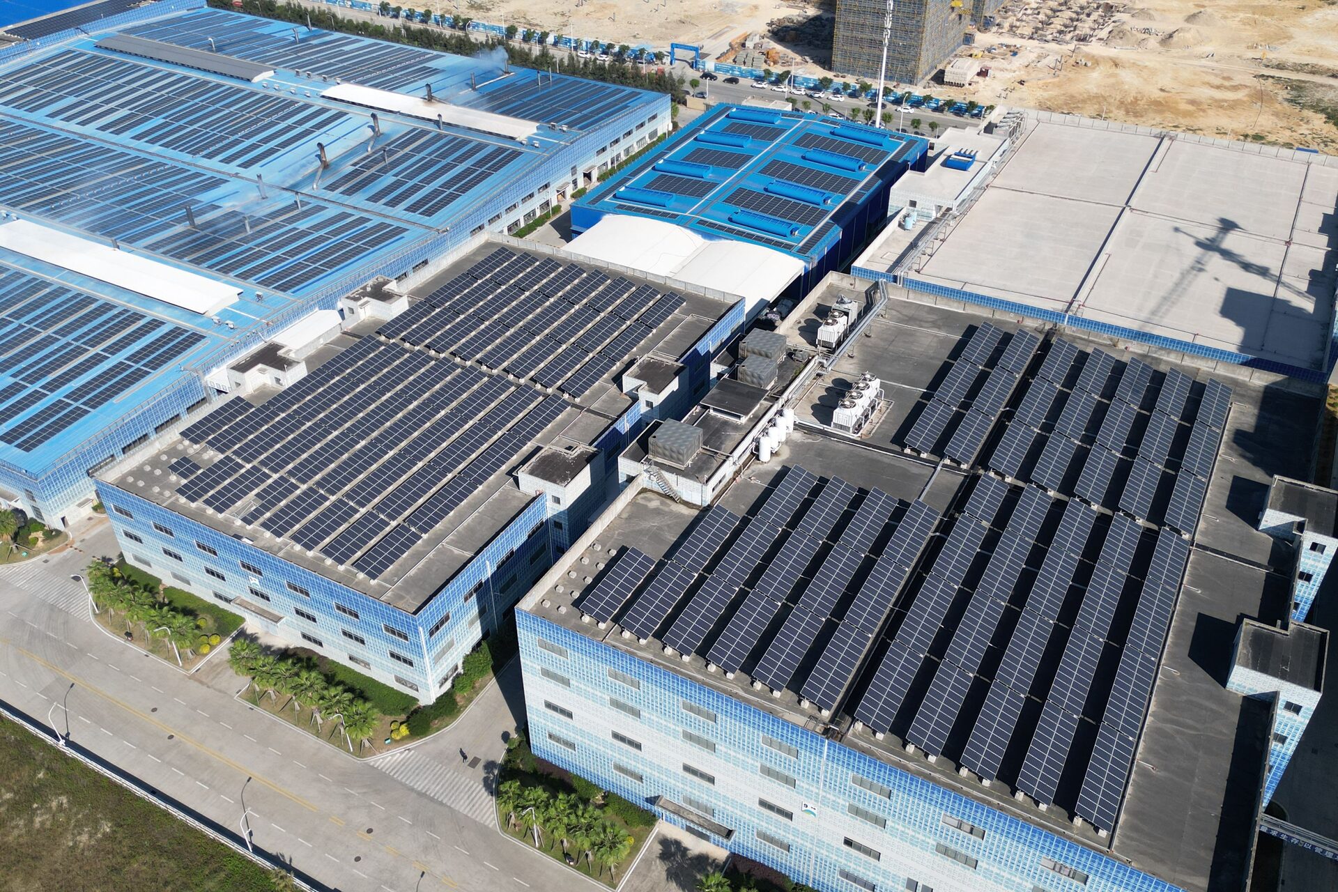 Vista aérea de complexo industrial com telhados cobertos por fileiras de painéis solares
